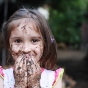 Foto von Mädchen mit Schlamm, Erde und Schmutz an Händen und im Gesicht