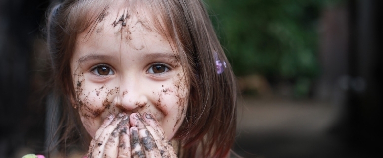 Foto von Mädchen mit Schlamm, Erde und Schmutz an Händen und im Gesicht