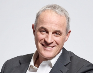 Portrait of Didier Pittet smiling in a grey jacket